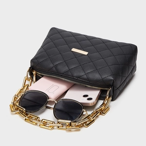 Quilted black crossbody bag with gold chain strap showing spacious interior storage