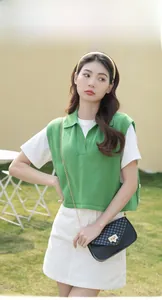 Outdoor model show featuring a green knitted vest and a black quilted chain handbag
