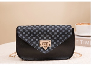Detail shot of the printed flap closure and golden metal clasp on a black crossbody bag