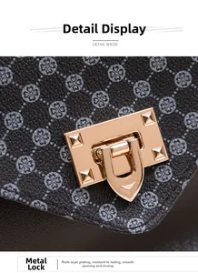 Detail showing the polished gold hardware lock and clover print on a black leather crossbody bag