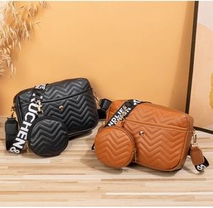 Detail of V-quilted crossbody bags in black and brown with wide logo fabric straps