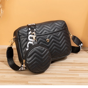 Close-up of black chevron quilted crossbody bag with small coin purse and lettered strap