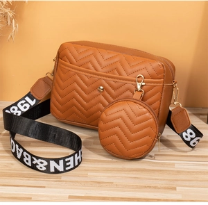 Brown chevron quilted shoulder bag featuring a wide logo strap and a mini round pouch