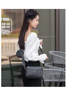 Detail of black chevron quilted crossbody bag with detachable mini round coin purse