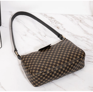 Detail of vintage geometric print handbag with black leather trim and golden hardware