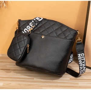 Détail du sac seau noir matelassé avec surpiqûres en V et large bandoulière textile