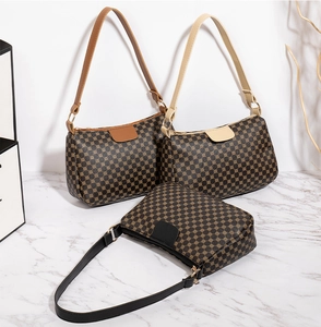 Three vintage baguette bags with geometric prints and contrast shoulder straps on marble
