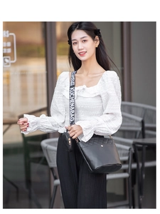 Gros plan du sac seau noir matelassé avec bandoulière tissée et mini pochette ronde