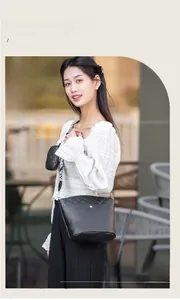 Détail du sac seau noir matelassé avec pochette ronde et large bandoulière logo