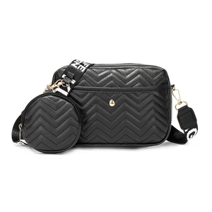 Black V-quilted crossbody bag with a round coin purse and white lettered webbing strap