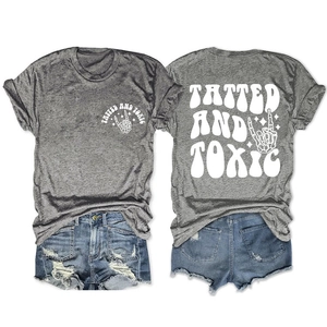 Flat lay of gray T-shirt with Tatted and Toxic print and ripped denim shorts set