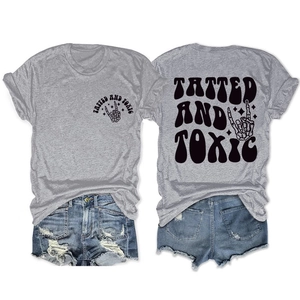Detail of grey t-shirt with Tatted and Toxic rock print and ripped denim shorts