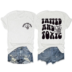 Flat lay of white cotton T-shirt featuring Tatted and Toxic skull hand graphic print