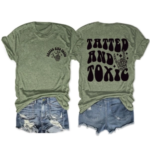 Olive green graphic t-shirt with Tatted and Toxic print and skeleton hand rock gesture
