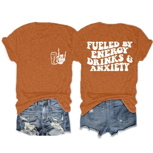 Détail d'un t-shirt orange en coton avec impression 'FUELED BY ENERGY DRINKS' au dos et graphique