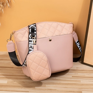 Sac seau matelassé rose avec motif en V et large bandoulière décorative imprimée