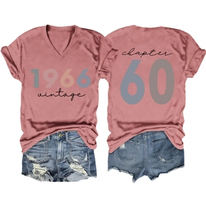 Flat lay of pink V-neck vintage 1966 T-shirt paired with distressed blue denim shorts
