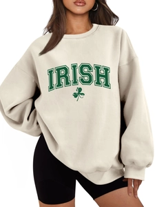 Detailed view of cream-colored crewneck sweatshirt with green Irish clover graphic