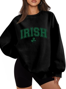 Detail of black long-sleeve sweatshirt showing green Irish Shamrock print and ribbed neckline