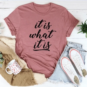 Flachbild des rosa 'it is what it is' T-Shirts mit Shorts und weißen Turnschuhen