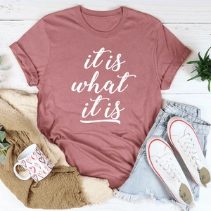 Flachgelegtes rosa Baumwoll-T-Shirt mit Textaufdruck und lässigen Denim-Shorts