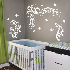 Detailed view of white floral vine and butterfly wall decals in a modern nursery setting