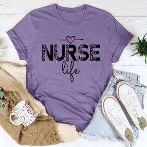 Flat lay of purple NURSE Life t-shirt with leopard print text and denim shorts