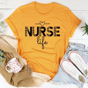 Flat lay of orange NURSE Life T-shirt with leopard print text, denim shorts and sneakers