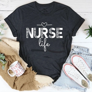 Flat lay of gray NURSE life t-shirt with leopard print text and casual accessories