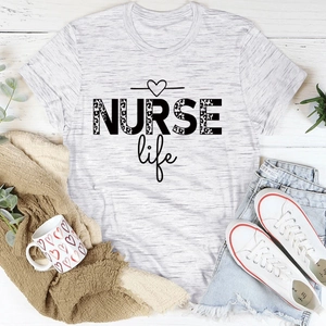 Flat lay of gray NURSE Life t-shirt with leopard print text on white wood background