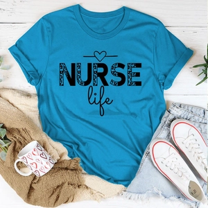 Close-up of NURSE Life t-shirt with leopard print text on white wooden background