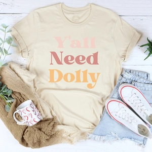 Mise à plat du t-shirt beige Y'all Need Dolly avec short en jean et baskets