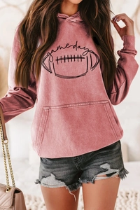 Gros plan du sweat à capuche rose avec texte game day et poignets côtelés