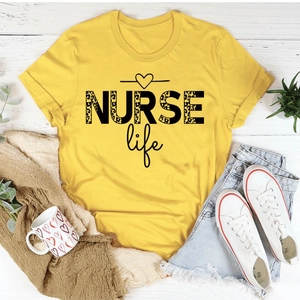 Flat lay of yellow cotton t-shirt with leopard NURSE Life print on white wooden floor