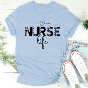 Flat lay of light blue NURSE Life T-shirt with leopard print text and denim shorts
