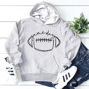 Détail du sweat à capuche gris clair game day avec imprimé football sur bois blanc