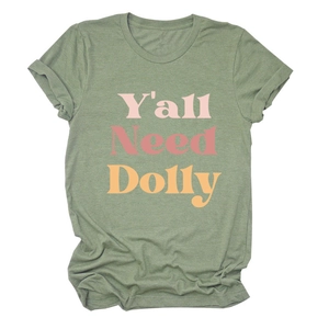 Détail d'un t-shirt vert sauge avec impression colorée de texte Y'all Need Dolly