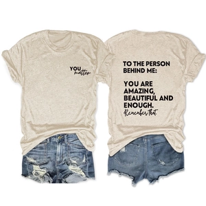 Flat lay of oatmeal T-shirt with back inspirational print and ripped denim shorts