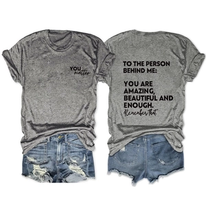 Detail of inspirational back print on gray casual t-shirt and ripped denim shorts set