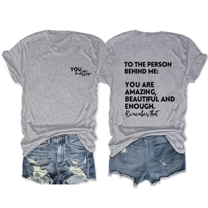 Flat lay of gray cotton T-shirt with back quote print and blue distressed denim shorts