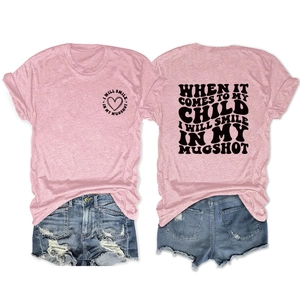 Detail view of pink cotton T-shirt featuring I WILL SMILE IN MY MUGSHOT slogan and heart print