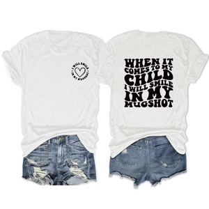 Detail of white cotton T-shirt featuring graphic text and distressed denim shorts ensemble