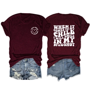 Detailed flat lay of burgundy graphic T-shirt and distressed denim shorts set