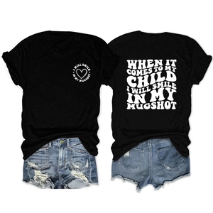 Flat lay of black cotton T-shirt with vintage white slogan and ripped denim shorts