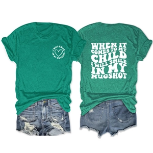 Front and back view of green T-shirt with 'I WILL SMILE IN MY MUGSHOT' slogan print