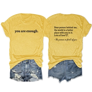 Detail of yellow t-shirt with you are enough slogan and blue ripped denim shorts