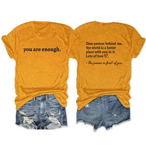 Detail of ginger yellow short sleeve t-shirt with back text and distressed denim shorts