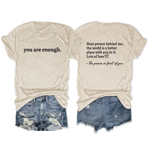 Flat lay of oatmeal cotton t-shirt with 'you are enough' print and denim shorts