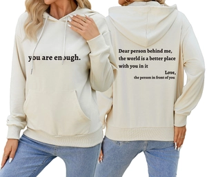 Détail de l'imprimé 'you are enough' et citation au dos sur sweat à capuche crème