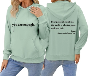 Détail du sweat à capuche vert sauge avec imprimé inspirant sur le devant et dans le dos